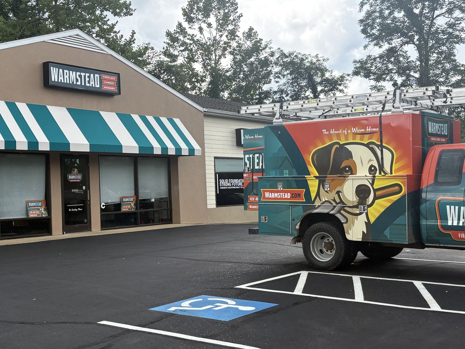Warmstead's Hendersonville, NC office at 1303 7th Avenue E, Suite C, with a branded Warmstead service truck parked out front